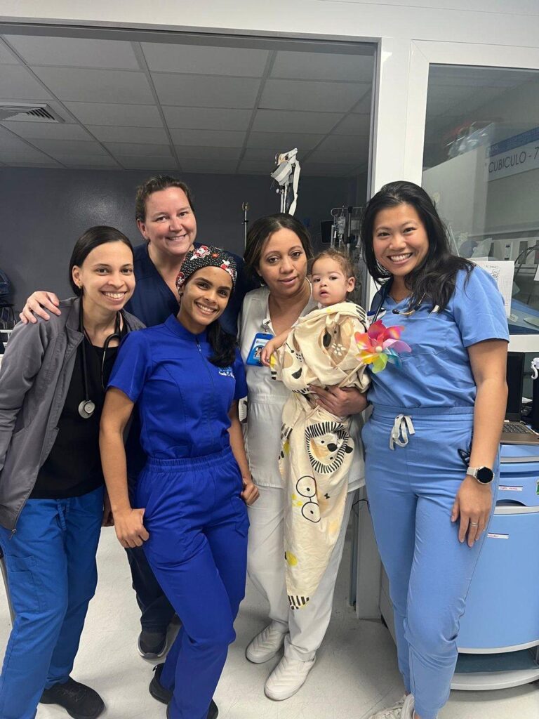 Equipo médico y de enfermería junto a una paciente